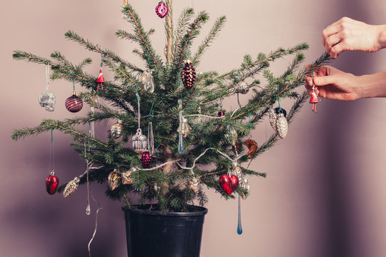 Hands decorating christmas tree