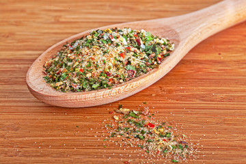 Salt with various herbs in a wooden spoon