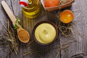 homemade mayonnaise into a bowl on a wooden surface