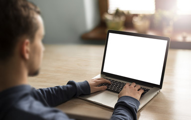 Man using notebook with blank screen in home interior.