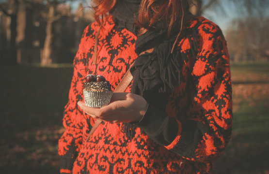 Woman in park with cupcake