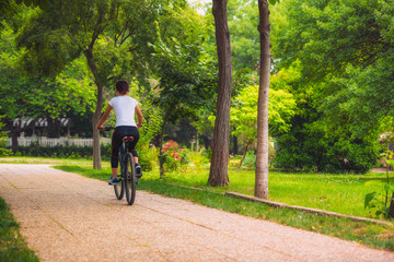 Fototapeta premium Cycling outdoor - Biker girl exercise in the park, woman fitness