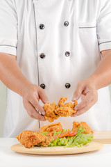 Obraz na płótnie Canvas Chefs holding fried chicken in plate for serve