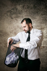Man searching document in paper bin