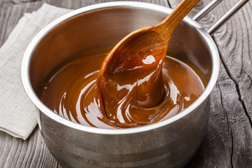 liquid caramel is poured into a gravy boat - 74772610