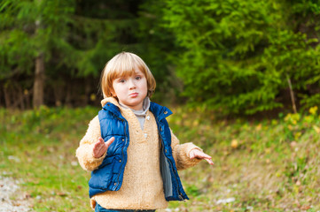 Adorable little boy walking in a forest on a nice fresh day