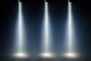 Foto op Plexiglas Licht en schaduw drie blauwe spotlichten op het podium