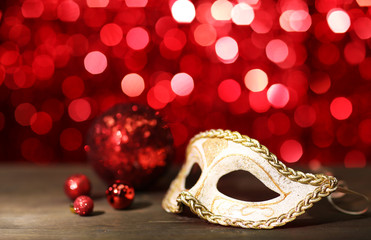Beautiful carnival mask on table on red background