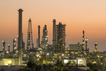 Obraz na płótnie Canvas Oil refinery plant at sunset, The night view of petroleum and petrochemical factory with distillation column, drum and pipeline. Gas, diesel and chemical business industry is important for economy.