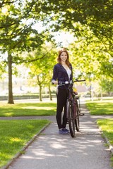 Fototapeta premium Pretty redhead with her bike