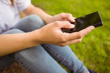 Mid section of a pretty redhead texting