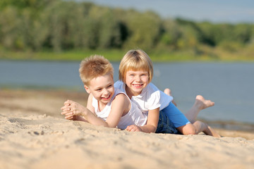 Fototapeta na wymiar Portrait of a boy and girl on the beach in summer