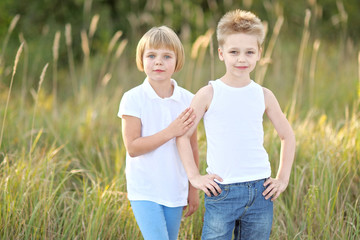 Fototapeta premium Portrait of a boy and girl on the meadow in summer