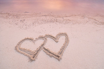 Love heart shape handwritten on the sand