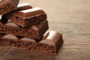 Tasty porous chocolate on wooden table