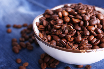 bowl of coffee beans stands on jeans background