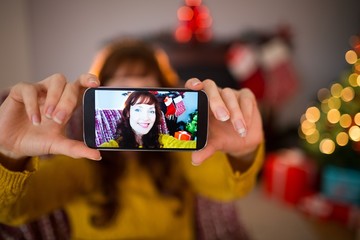 Smiling redhead taking a selfie at christmas