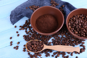 Two bowls of ground coffee and coffee beans near wooden spoon