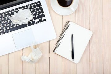 Open notebook, crumbled papers, diary and a cup of coffee