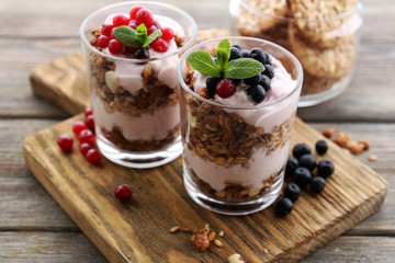 Healthy layered dessert with muesli and berries on table