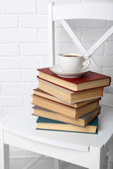 Pile of books with cup of hot drink