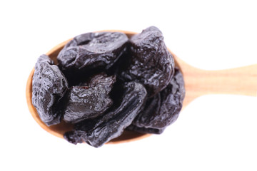 Wooden spoon of prunes isolated on white