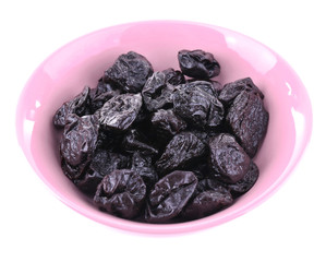 Purple bowl of prunes isolated on white