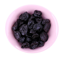 Purple bowl of prunes isolated on white