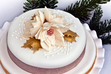 Iced round cake decorated with Christmas roses.