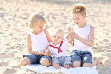 Fototapeta premium portrait of three little boys on the beach in summer