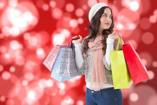 Composite image of thoughtful brunette with shopping bags