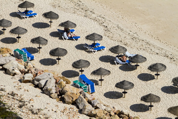 Fototapeta na wymiar Top view of a section of straw umbrellas on a beach.