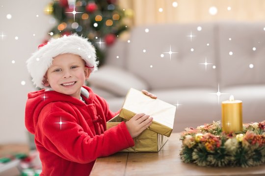 Composite image of festive little boy opening a gift
