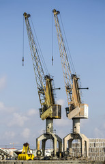 Fototapeta na wymiar View of silhouettes of crane towers in the docks.
