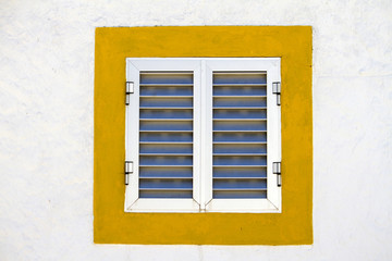 Close up view of a modern aluminum window with a yellow frame.