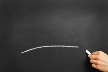 Hand zeichnet Strich aus Kreide an Tafel