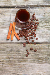 Transparent cup of coffee, beans and cinnamon sticks
