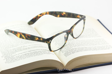 Libro e un paio di occhiali aperti