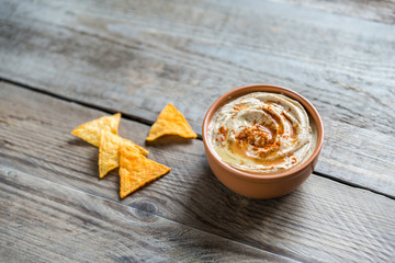 A bowl of hummus with corn chips