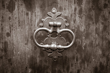 Ancient door handle. Sepia. Stylization.