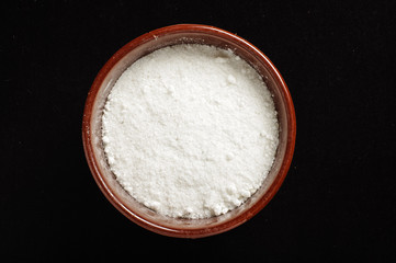 A bowl of common salt isolated on the dark background