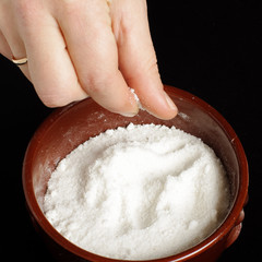 Female hand holding pinch of salt