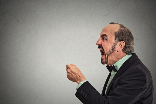 Angry frustrated man screaming isolated grey background 
