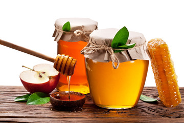 Glass cans full of honey, apples and honeycombs wood. File conta