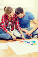 smiling couple looking at color samples at home
