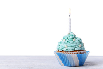 Delicious birthday cupcake on table on white background