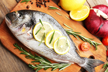 Fresh raw fish and food ingredients on table