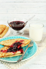Plate of delicious pancakes with berry jam on wooden background