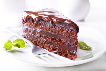 Delicious chocolate cake on plate on table on light background