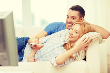 Obraz na płótnie Canvas smiling couple watching movie at home